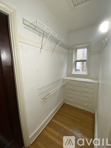 A room with a window and a wooden floor.