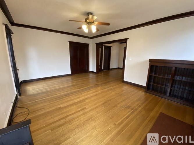 A room with wooden flooring and a ceiling fan.