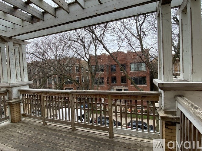A balcony with a railing and a view of a building and trees.