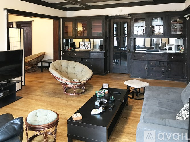 A living room with a black couch and a white chair.