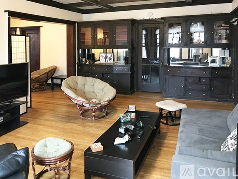 A living room with a black couch and a white chair.