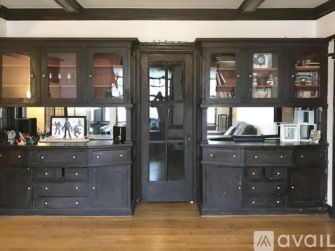 A black cabinet with glass doors and drawers is in the foreground of the image.