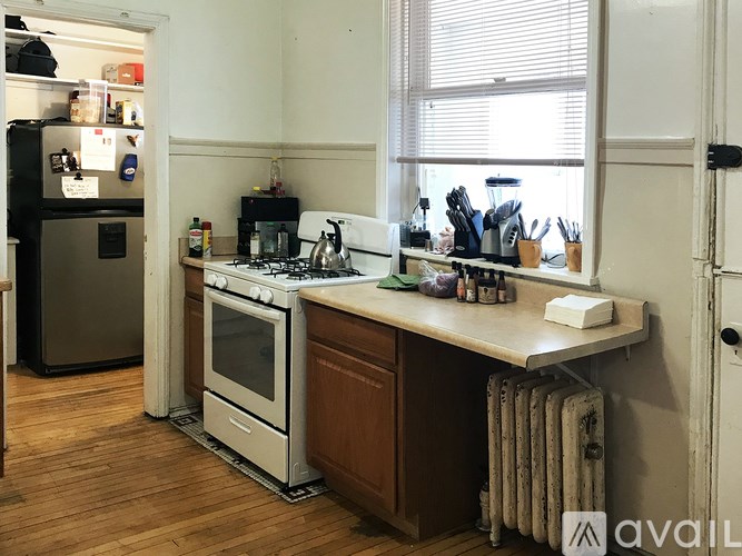 A kitchen with a refrigerator, oven, and sink.