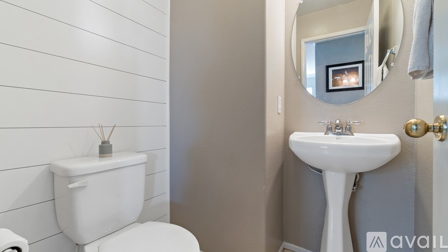 A white toilet sits next to a white pedestal sink in a bathroom.
