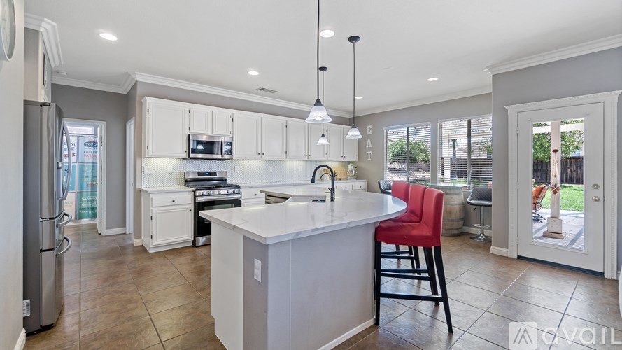 A modern kitchen with a refrigerator, stove, and sink.