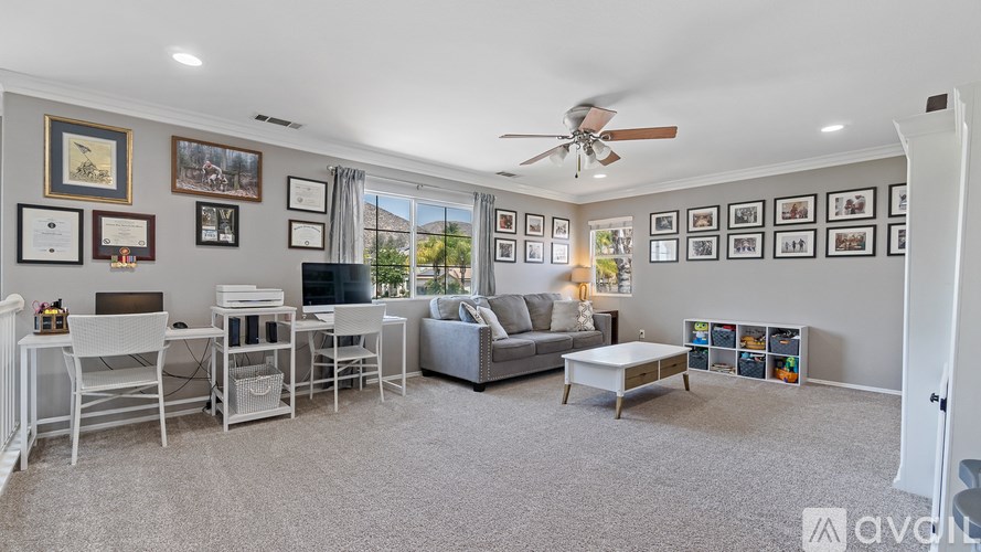 A living room with a white sofa, a coffee table, and a wall of framed pictures.