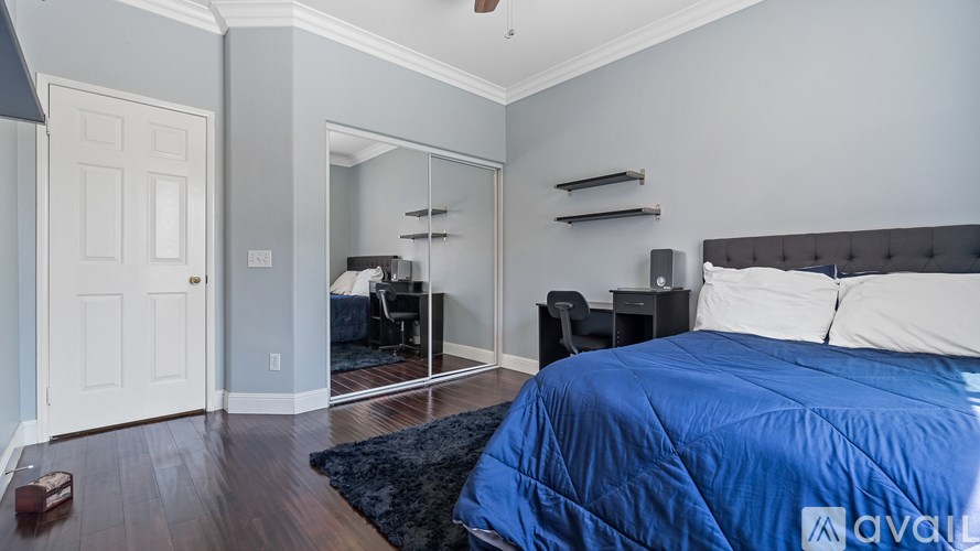 A bedroom with a bed, a dresser, and a mirror.