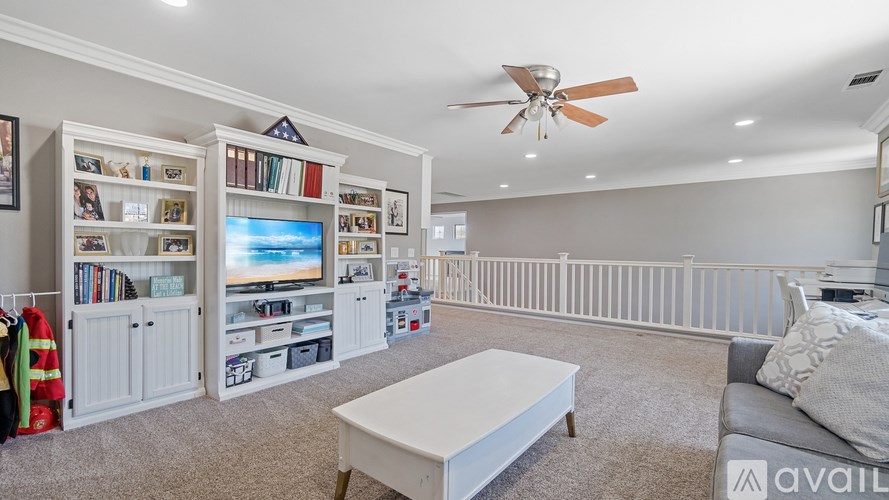 A living room with a television, bookshelves, and a couch.