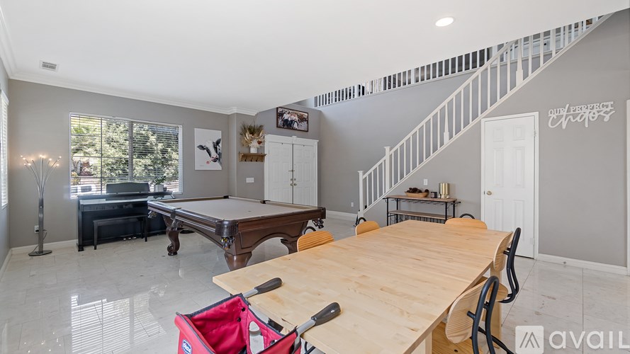 A room with a pool table and a wooden table.