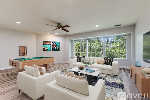 A living room with a pool table and a couch.