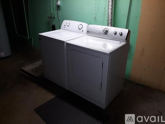 A white washing machine is on a black mat in a room.