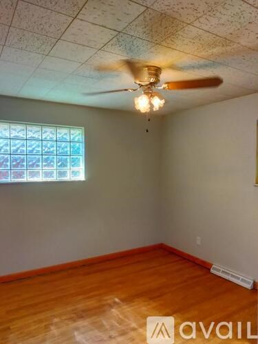 A room with a ceiling fan and a window.