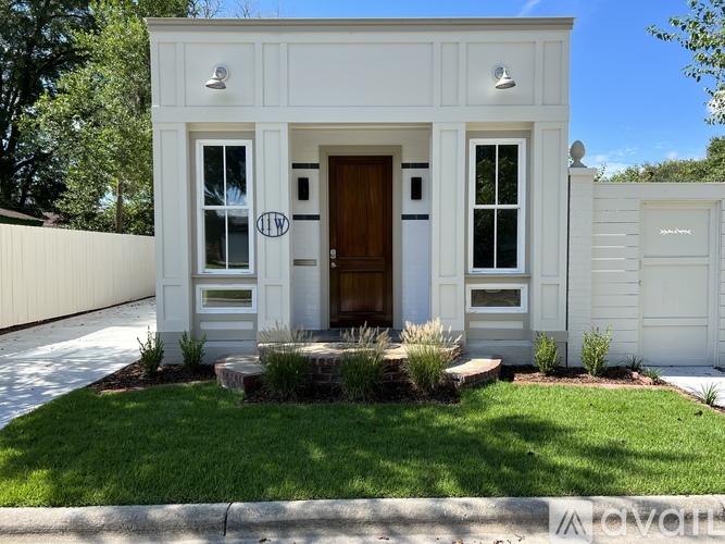 A white house with a brown door and windows.