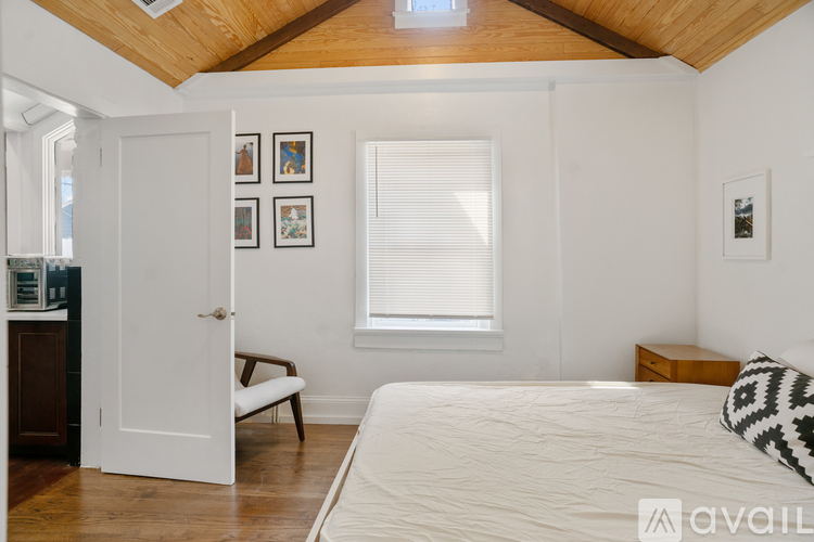 A bedroom with a bed, a chair, and pictures on the wall.