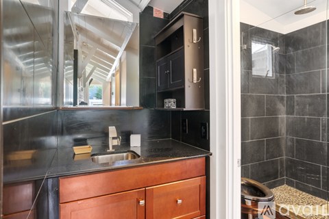 A modern kitchen with dark wood cabinets and a black countertop.