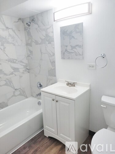 A white bathroom with a marble wallpaper and a white cabinet.