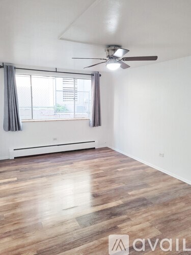 A room with wooden flooring and a ceiling fan.