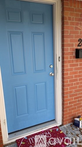 A blue door with a number 2 on the brick wall.