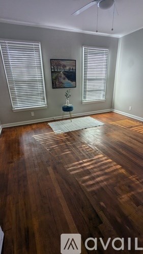 A room with wooden flooring and a ceiling fan.