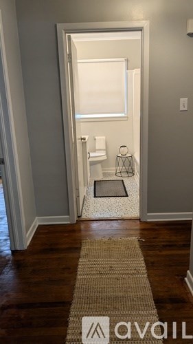 A bathroom with a towel rack and a rug.