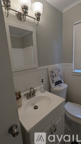 A bathroom with a sink, toilet, and a mirror.