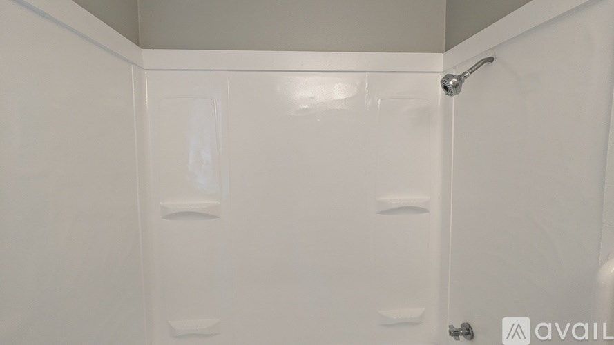 A white shower stall with a shower head and a door.