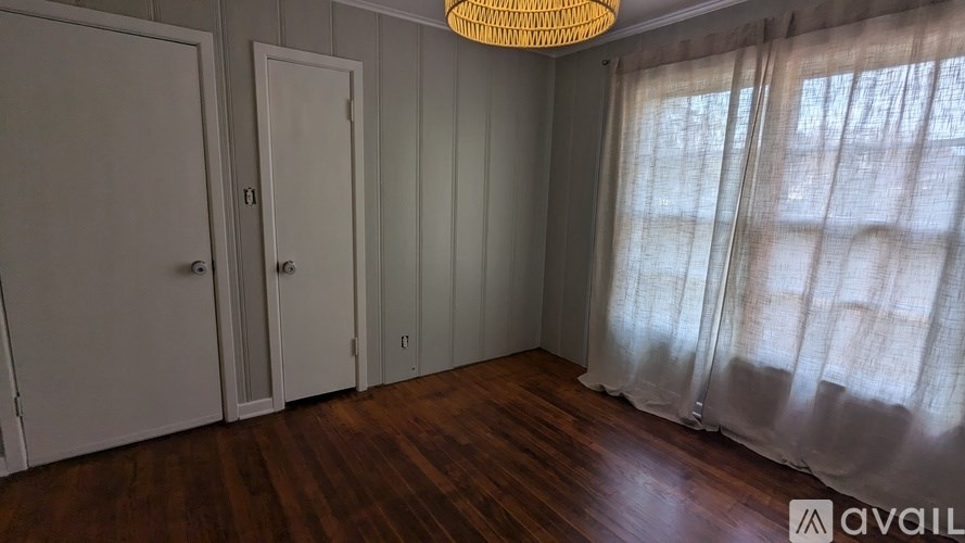 A room with wooden floors and white doors.