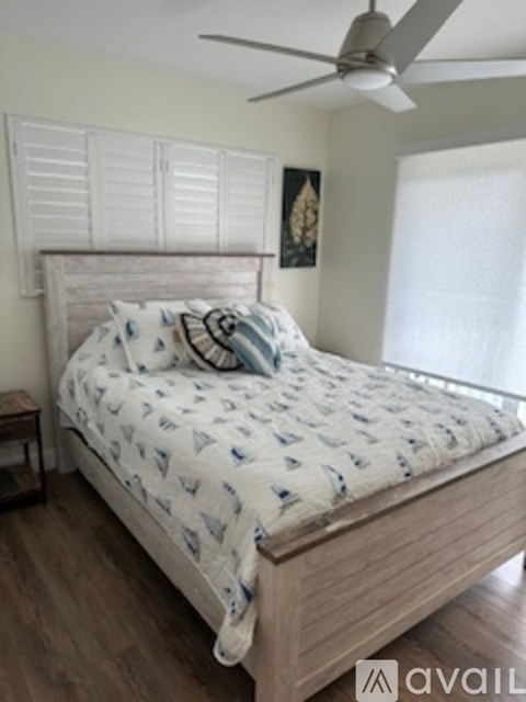 A bed with a white and blue comforter is in the image.
