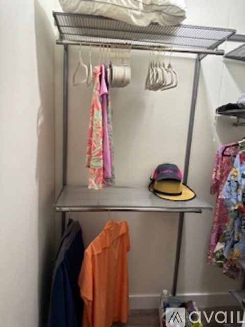 A metal clothes rack with clothes hanging on it.