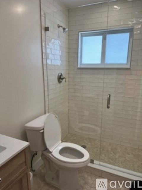 A white toilet in a bathroom with a glass shower door.