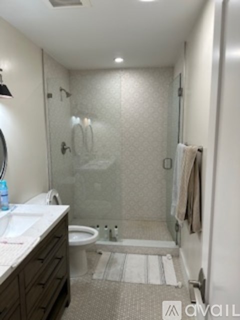 A bathroom with a toilet, sink, and shower.