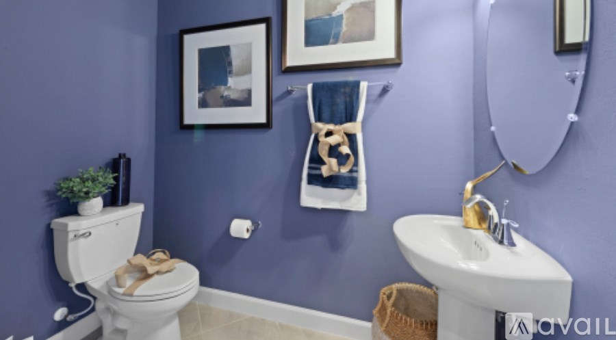 A bathroom with a toilet, sink, and mirror.