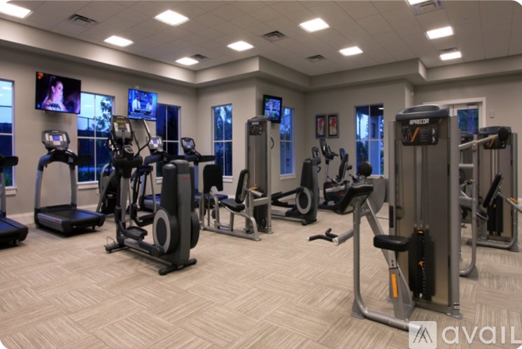 A gym with a variety of exercise equipment including treadmills, stationary bikes, and weight machines.