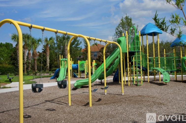 A playground with a yellow frame and a green slide.
