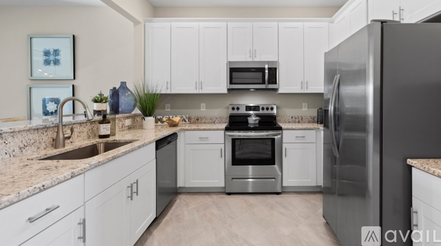 A modern kitchen with white cabinets and stainless steel appliances.