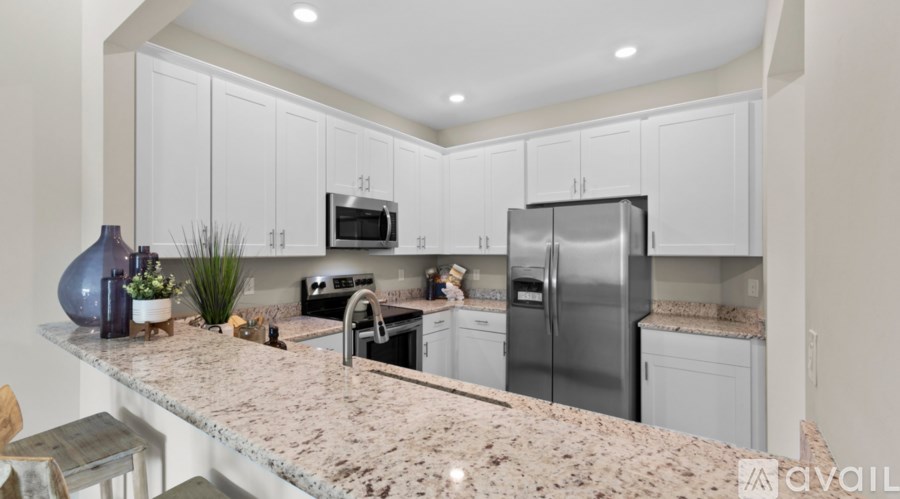 A kitchen with granite countertops and stainless steel appliances.