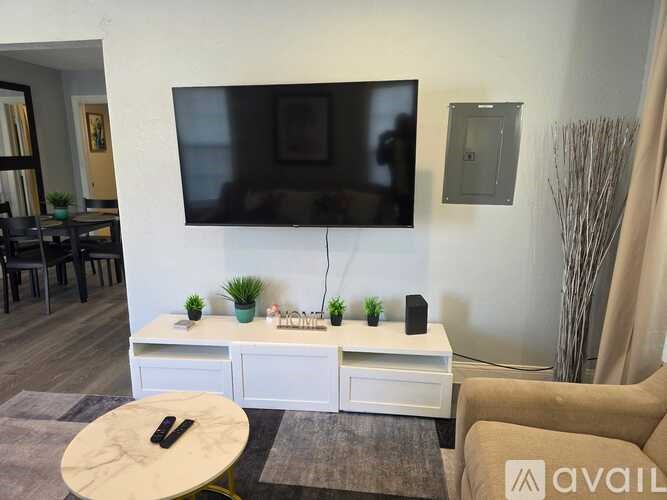 A living room with a television, a white cabinet, and a small table.
