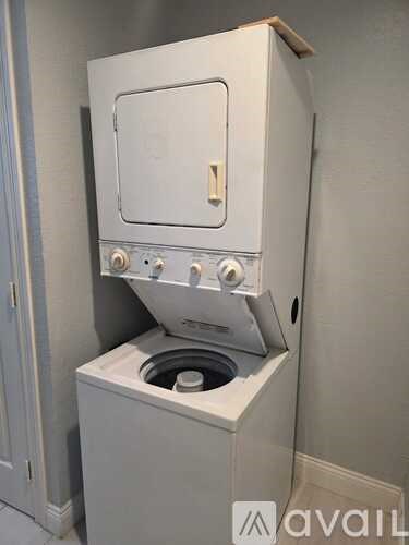 A white oven with a door open is installed in a wall.