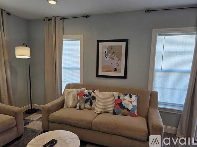 A living room with a couch, a table, and a lamp.