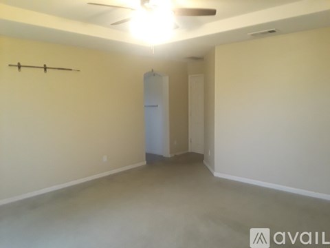 A room with a ceiling fan and a wall-mounted coat rack.