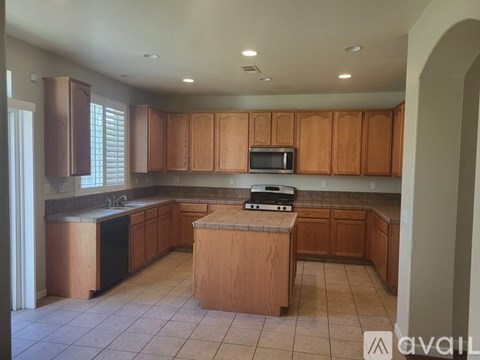 A kitchen with wooden cabinets and a microwave on the counter.