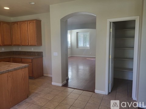 A kitchen with wooden cabinets and a tiled floor.