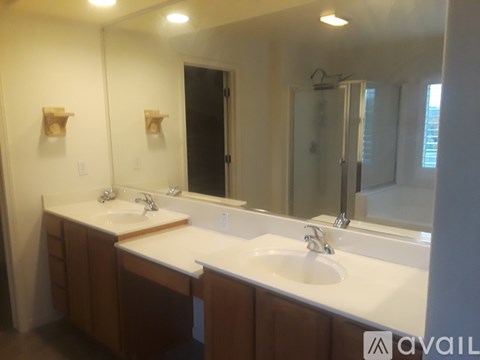 A bathroom with two sinks and a large mirror.