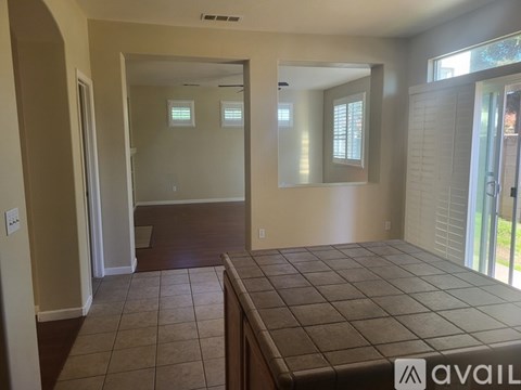 A tiled floor leads to a hallway with a mirrored wall.