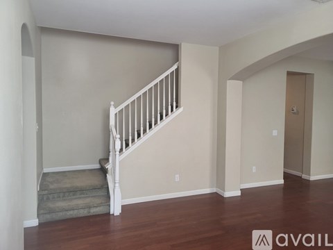 A spacious room with a staircase leading to the upper level.