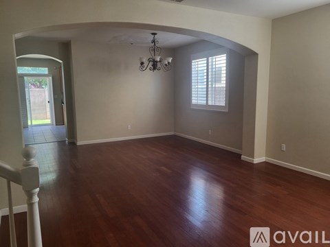 A room with wooden floors and a chandelier.