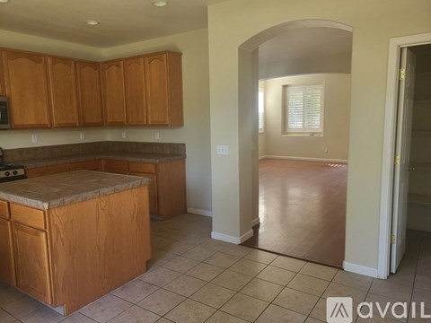 A kitchen with wooden cabinets and a tiled floor.