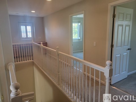A staircase with white railings leads to a second floor.
