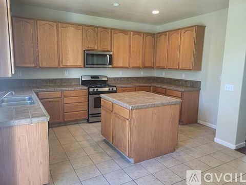 A kitchen with wooden cabinets and a granite countertop.