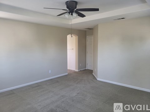A room with a ceiling fan and carpeted floor.